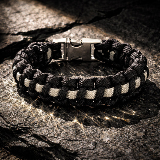 Black and white braided bracelet on a textured stone surface