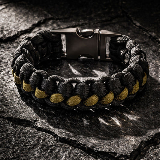 Black and Olive green bracelet with braided design and metal clasp on a dark stone surface